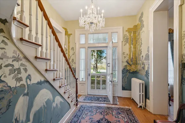 a view of an entryway with wooden floor and a chandelier