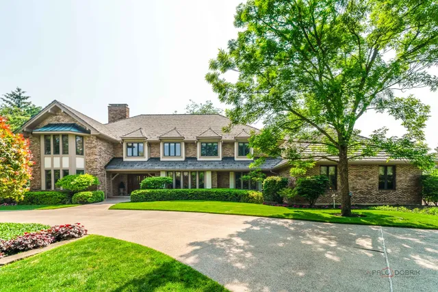 a view of a big house with a big yard and large trees