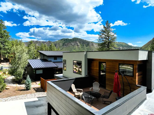 a view of a couches and dinning table and chairs in the balcony