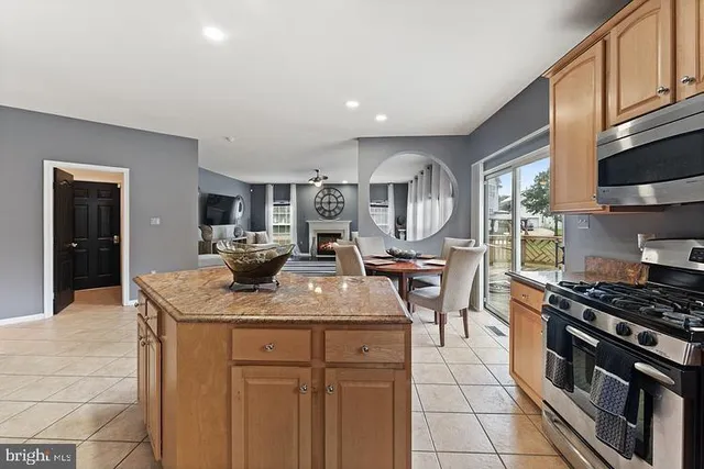 a kitchen with kitchen island granite countertop a stove and a sink