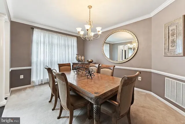 a view of a dining room with furniture and a chandelier