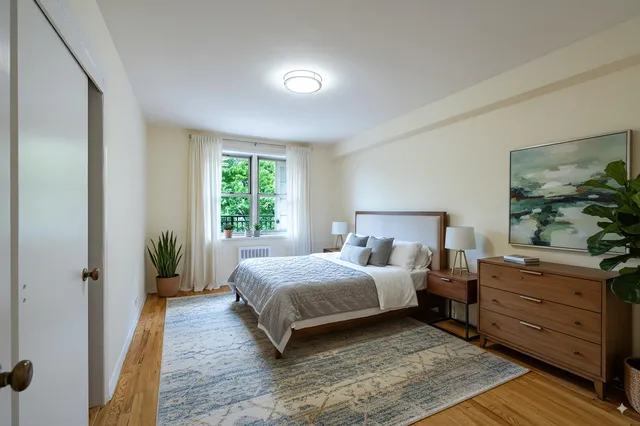 a bedroom with a bed windows and a potted plant