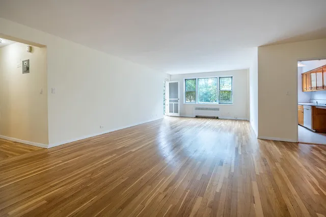 a view of empty room with wooden floor
