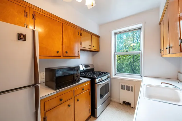 a kitchen with a refrigerator sink and cabinets