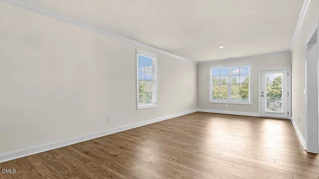 an empty room with wooden floor and window