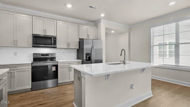 a kitchen with stainless steel appliances granite countertop a stove a sink and a refrigerator