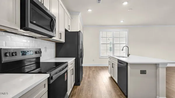 a kitchen with stainless steel appliances granite countertop a sink a stove and a microwave