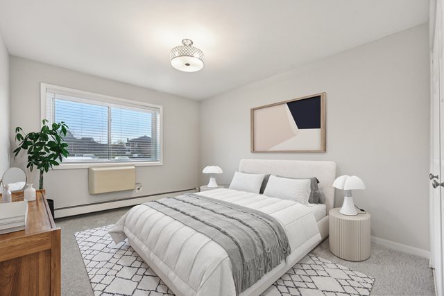 2226 South Goebbert Road, Unit 172 Arlington Heights, IL 60005 - Photo 15 of 22 a bedroom with a large bed and a potted plant