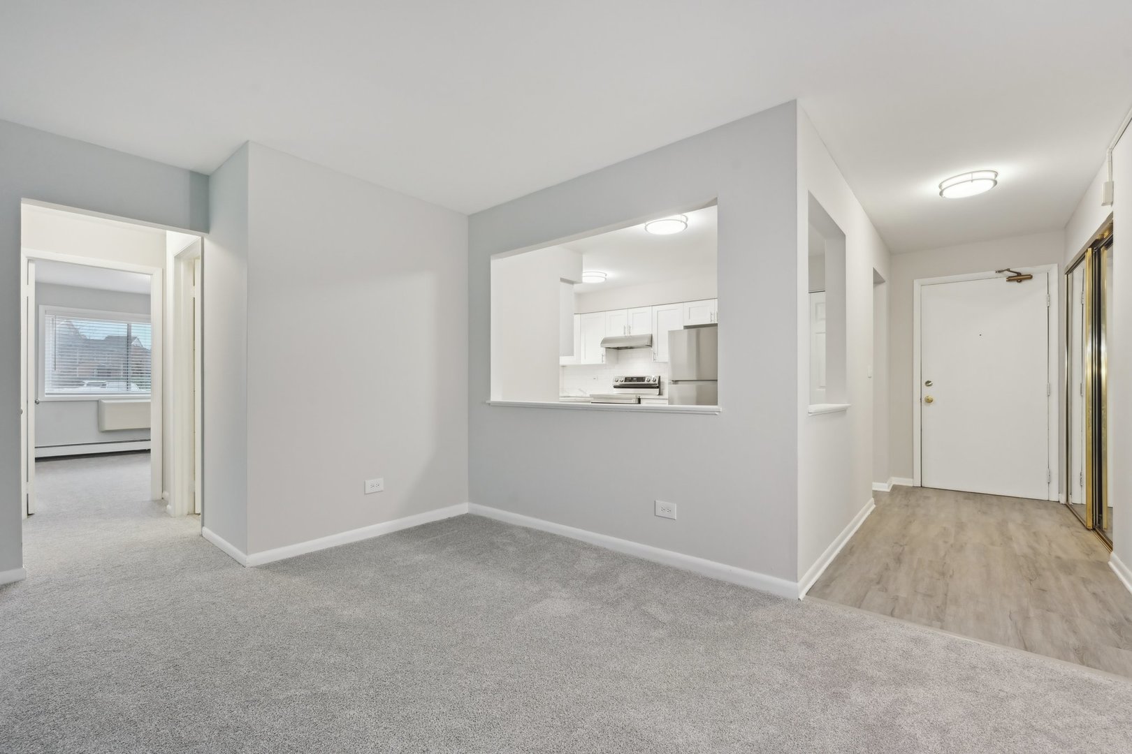 2226 South Goebbert Road, Unit 172 Arlington Heights, IL 60005 - Photo 6 of 22 a view of an empty room with wooden floor and a mirror