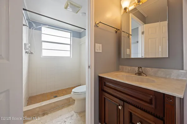 a bathroom with a sink a toilet and shower