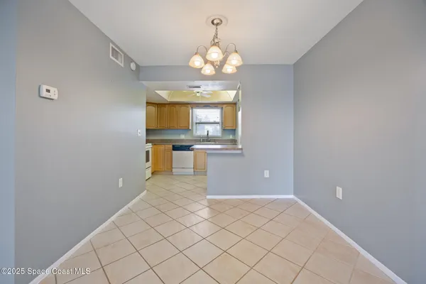 a view of a kitchen with wooden floor and a chandelier