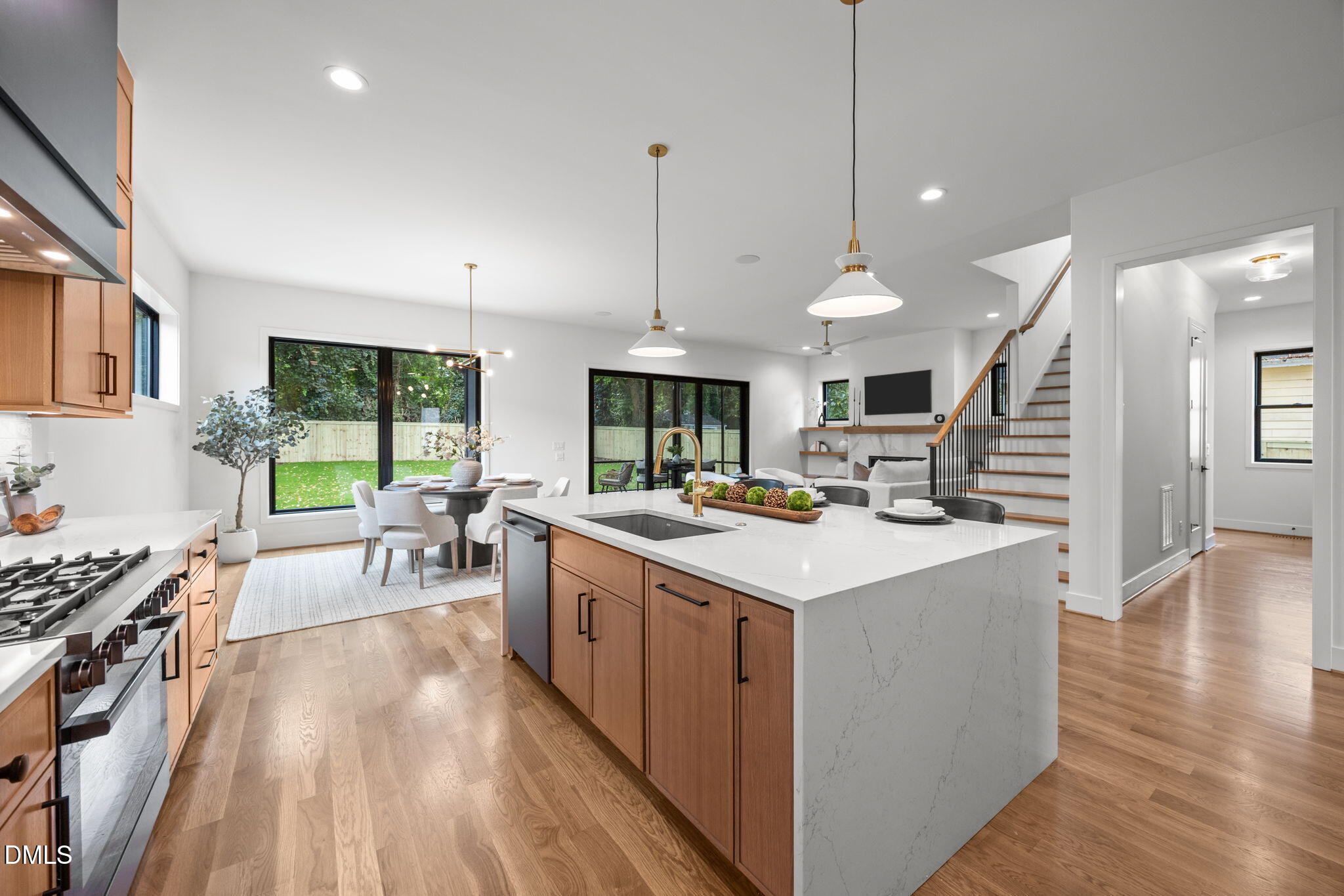 406 Columbia Drive Raleigh, NC 27604 - Photo 15 of 47 a kitchen with stainless steel appliances granite countertop a stove oven a dining table chairs with white cabinets and wooden floor