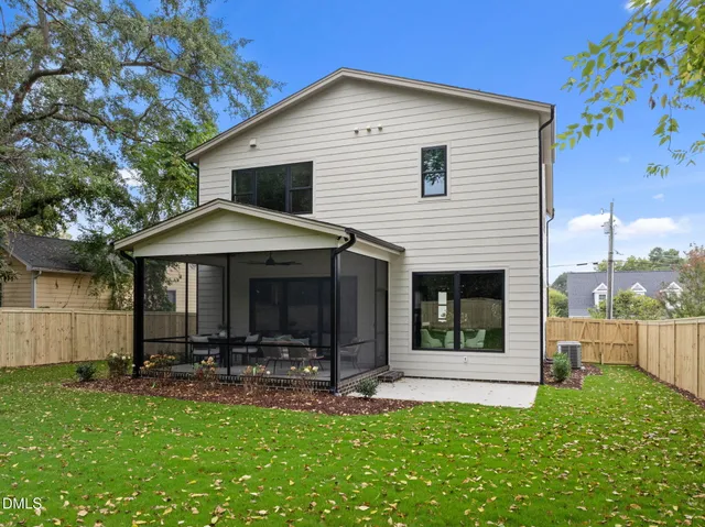 a kitchen with stainless steel appliances granite countertop a stove oven a dining table chairs with white cabinets and wooden floor