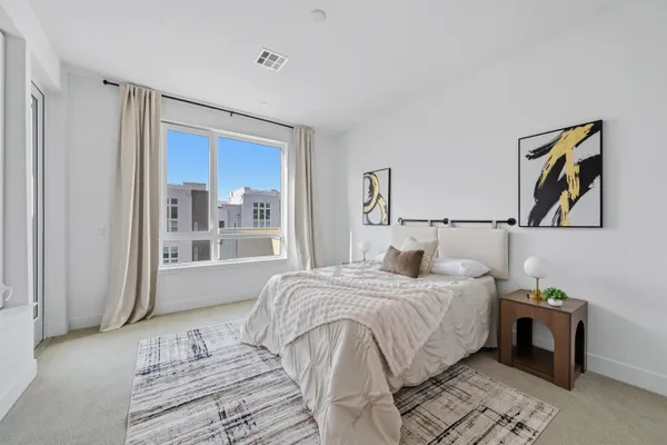 a bedroom with a bed a mirror and a window