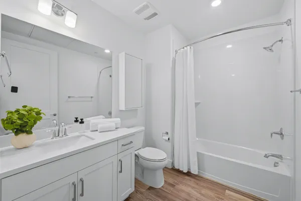 a bathroom with a shower sink vanity mirror and bathtub