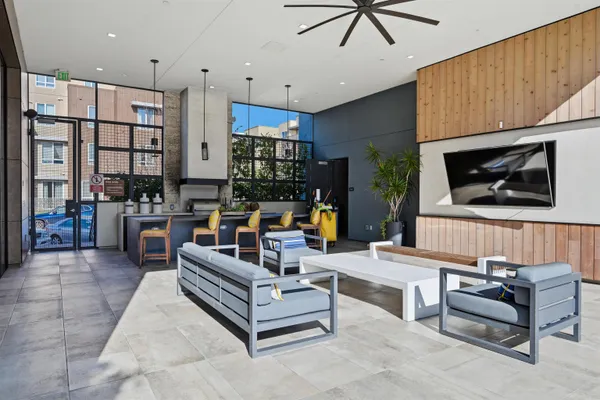 a living room with furniture a flat screen tv and kitchen view