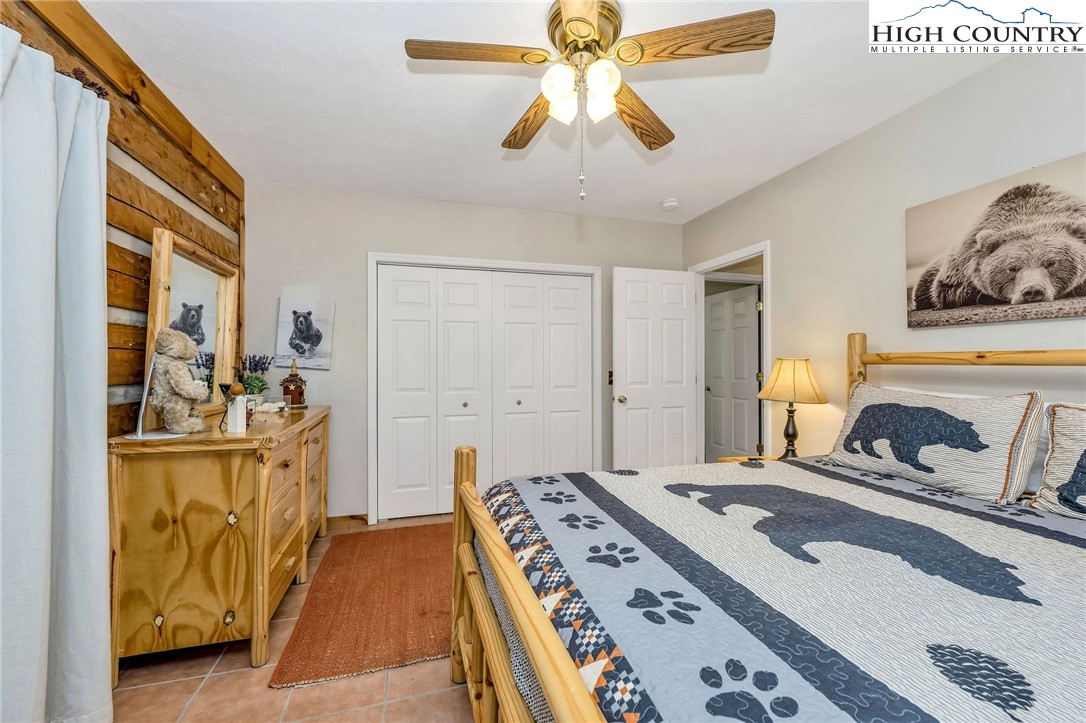 251 Stone Valley Road Grassy Creek, NC 28631 - Photo 22 of 46 a bedroom with a bed and a chandelier