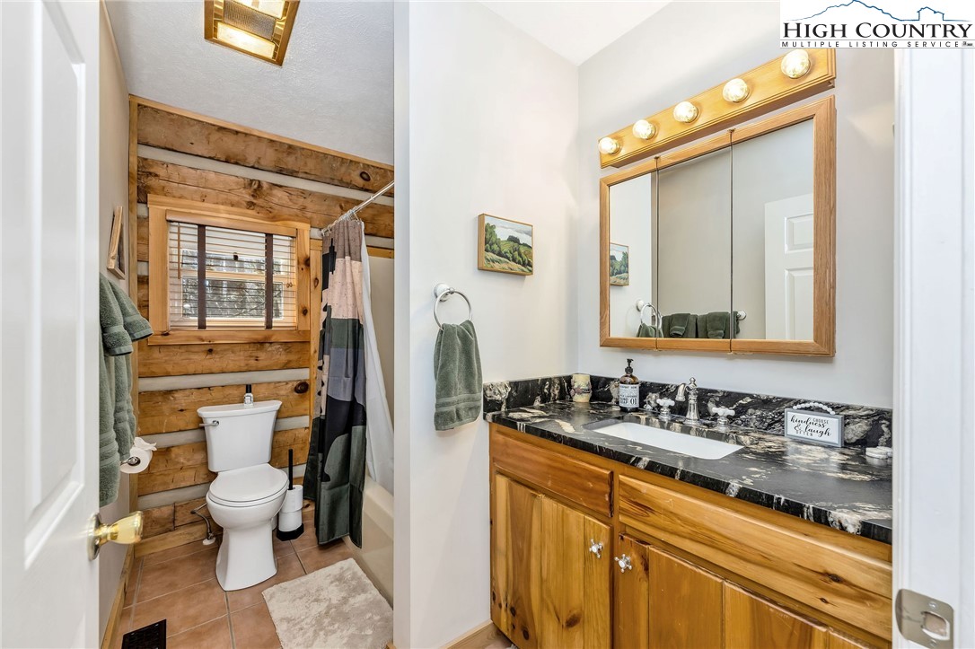 251 Stone Valley Road Grassy Creek, NC 28631 - Photo 23 of 46 a bathroom with a granite countertop sink mirror and a toilet
