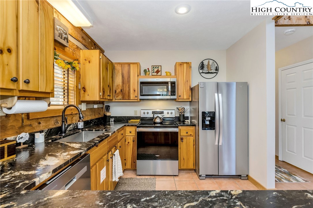 251 Stone Valley Road Grassy Creek, NC 28631 - Photo 10 of 46 a kitchen with stainless steel appliances granite countertop a stove a sink and a refrigerator