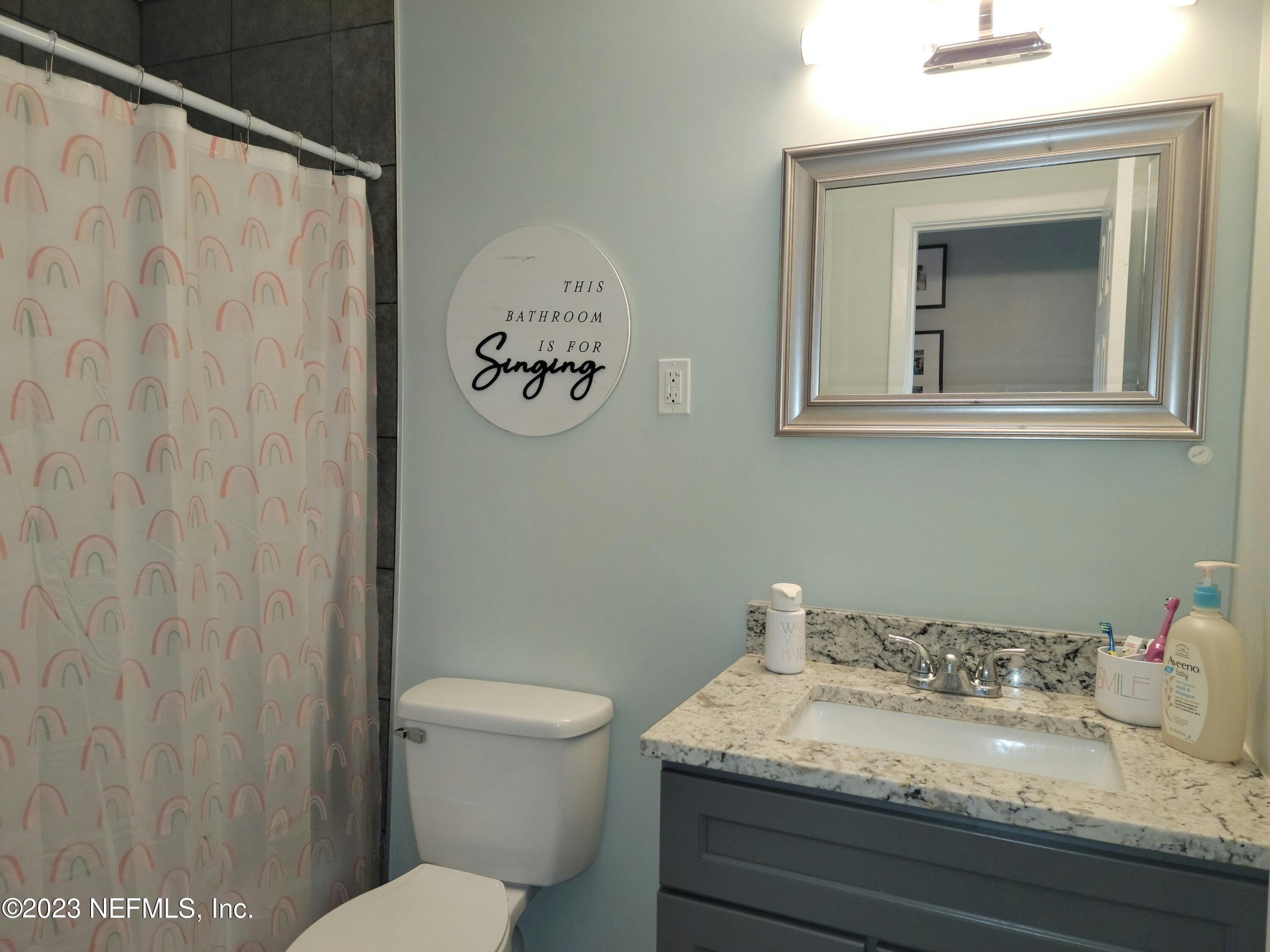 5452 Community Road Jacksonville, FL 32207 - Photo 13 of 23 a bathroom with a granite countertop sink mirror vanity and toilet
