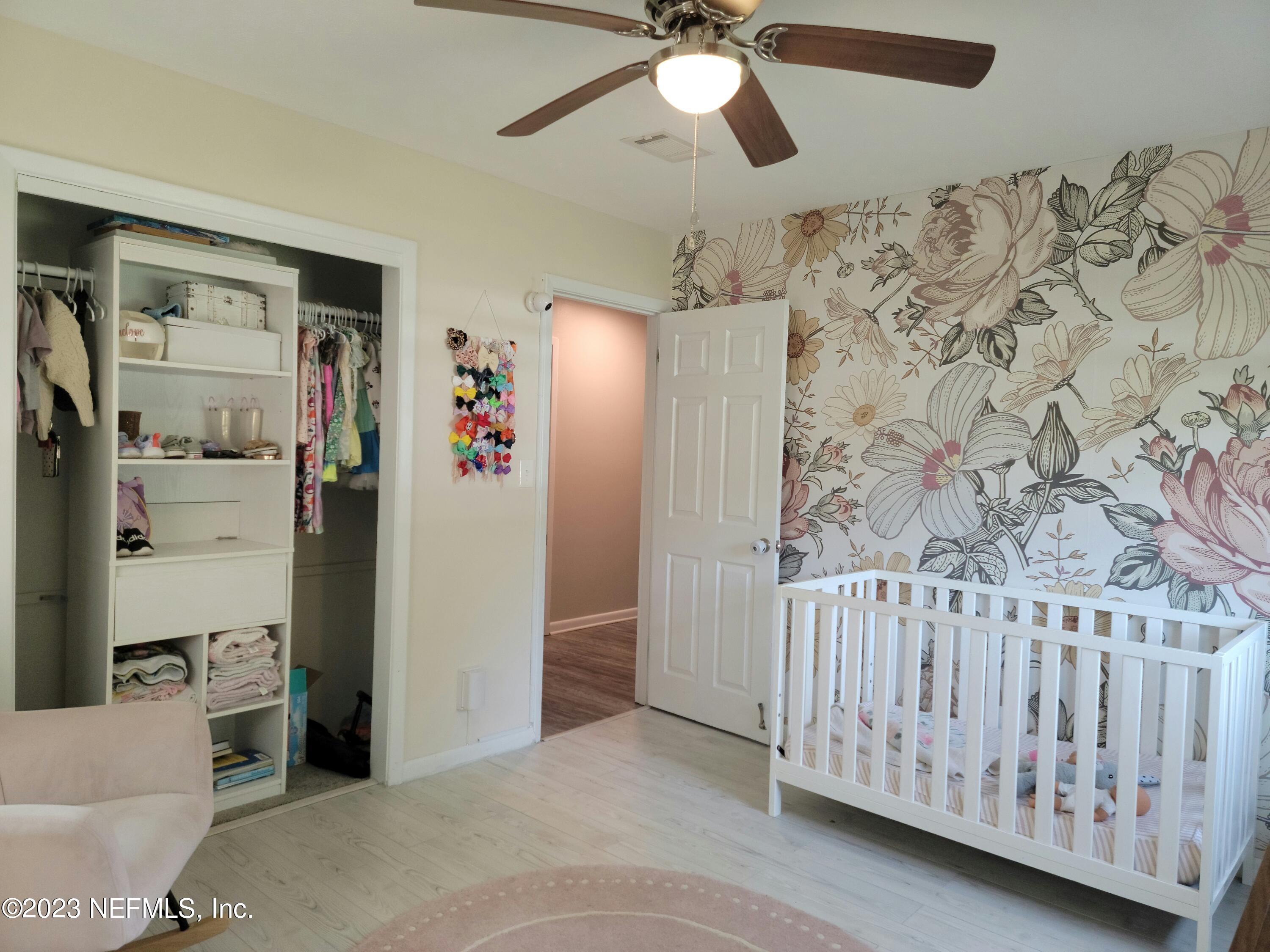 5452 Community Road Jacksonville, FL 32207 - Photo 14 of 23 a view of a livingroom with wooden floor and a ceiling fan