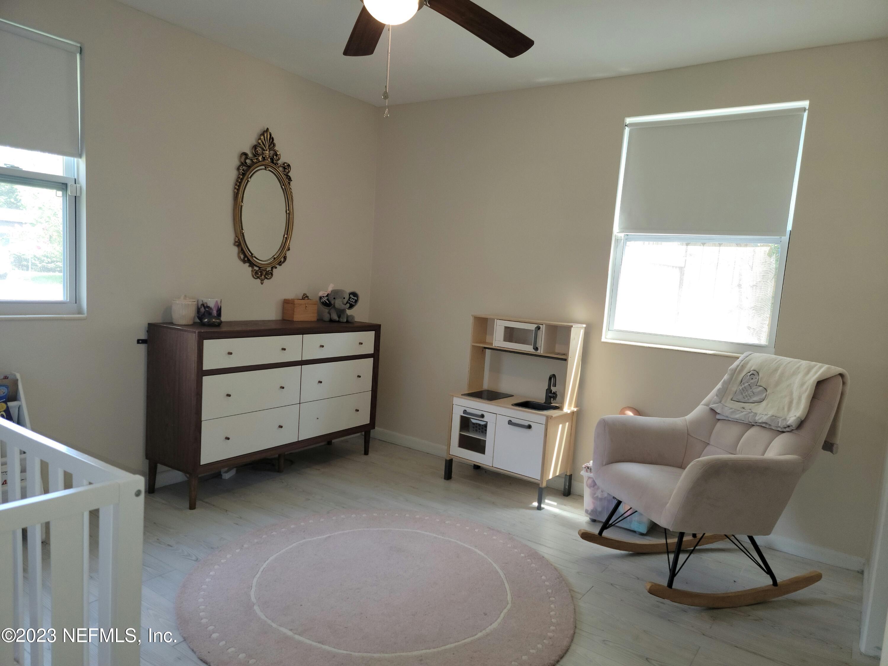 5452 Community Road Jacksonville, FL 32207 - Photo 15 of 23 a living room with furniture a window and a chandelier
