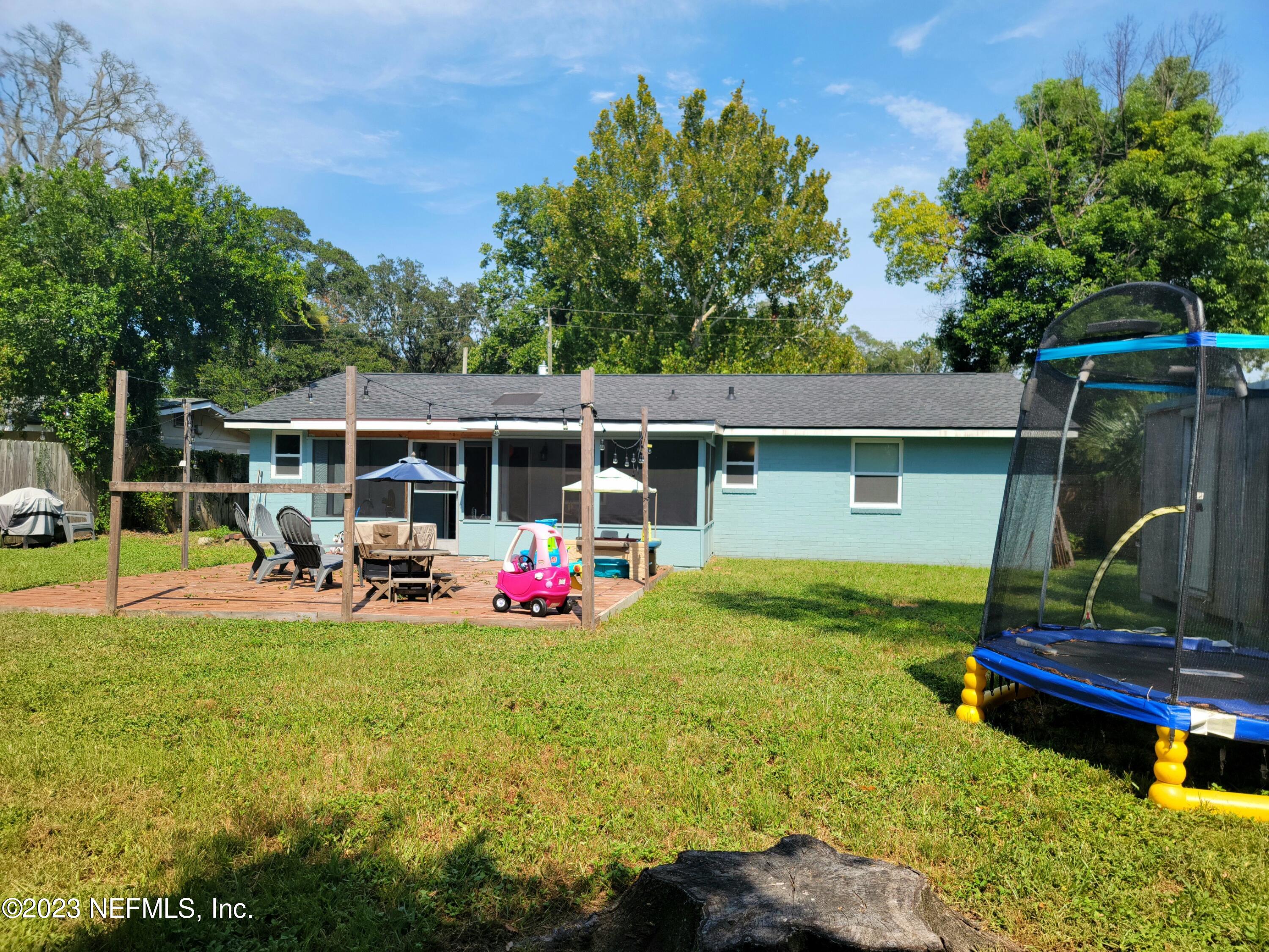 5452 Community Road Jacksonville, FL 32207 - Photo 23 of 23 a view of a backyard with table and chairs and potted plants with wooden fence