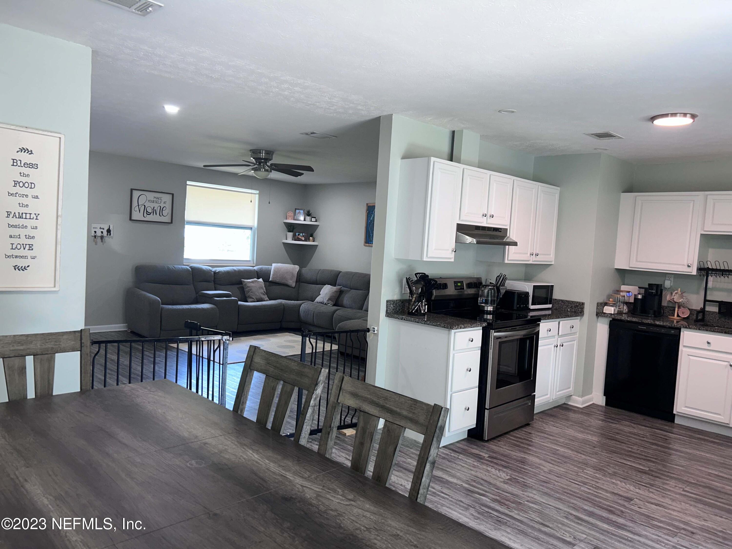 5452 Community Road Jacksonville, FL 32207 - Photo 7 of 23 a kitchen with sink a microwave cabinets and dining table