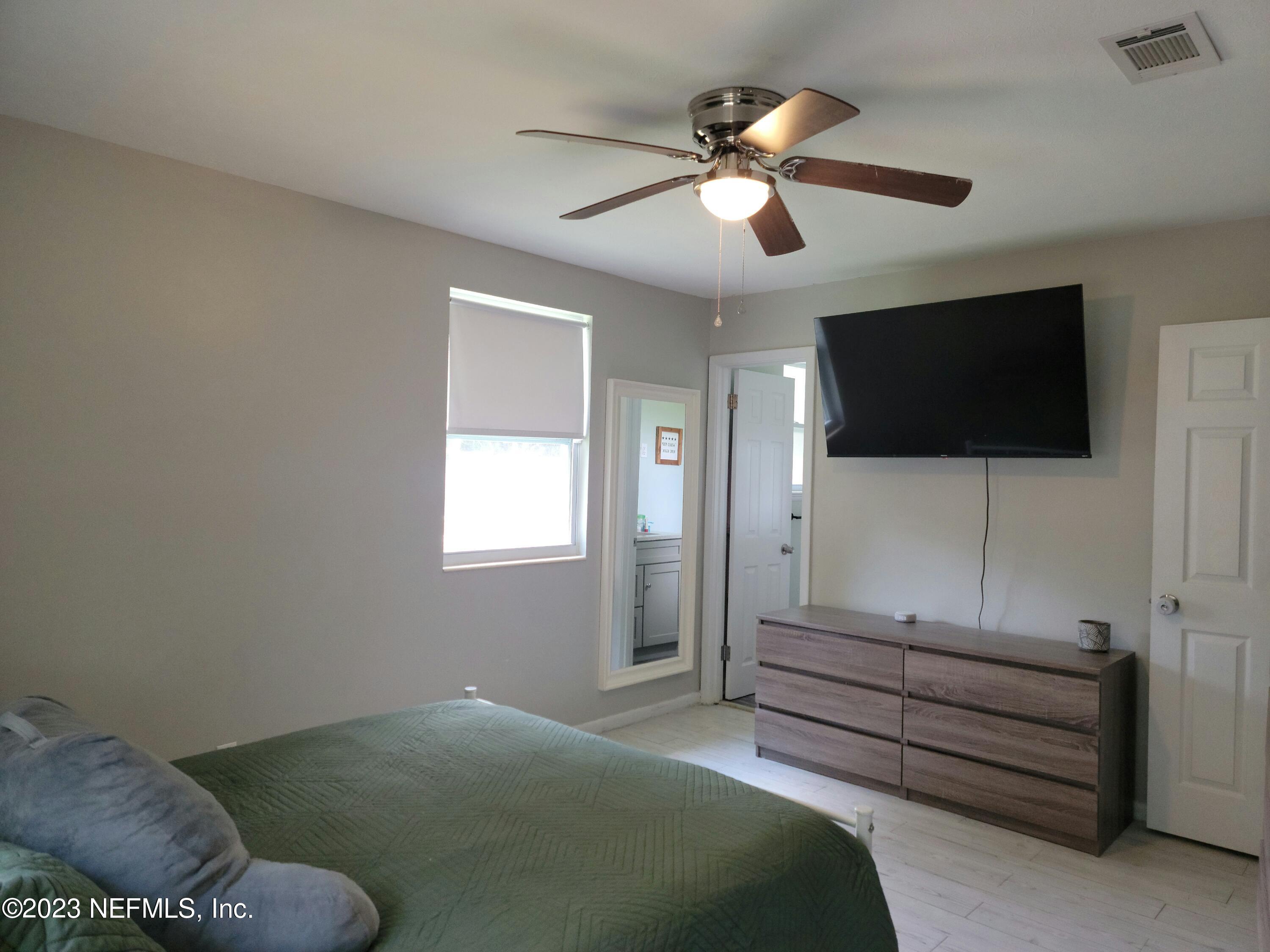 5452 Community Road Jacksonville, FL 32207 - Photo 10 of 23 a bedroom with furniture and a flat screen tv