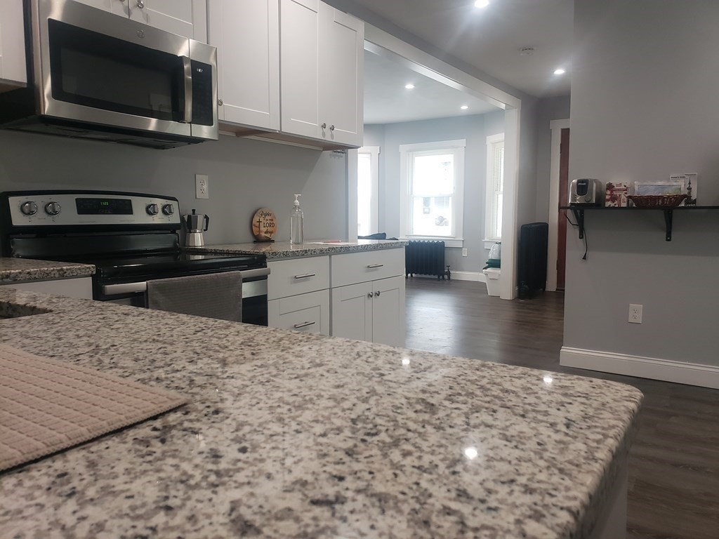 19 Wareham Street Springfield, MA 01108 - Photo 17 of 25 a kitchen with microwave a stove and cabinets