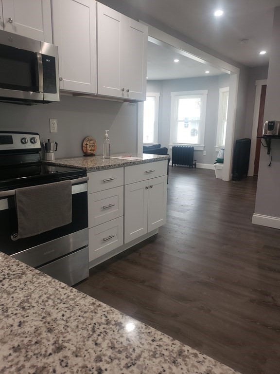 19 Wareham Street Springfield, MA 01108 - Photo 7 of 25 a kitchen with stainless steel appliances kitchen island granite countertop a stove a sink and a microwave