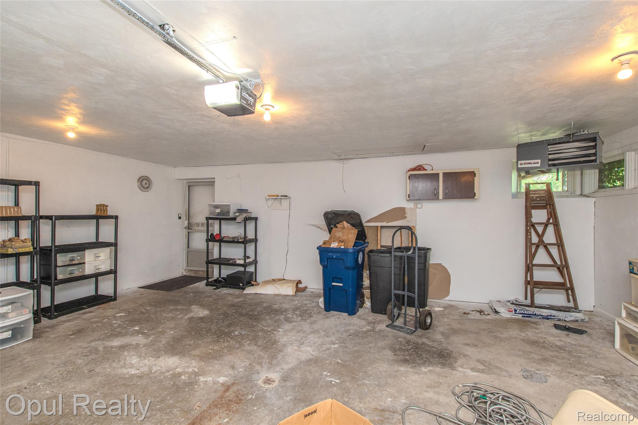 6455 Norham Road Bloomfield Hills, MI 48301 - Photo 59 of 93 Spacious garage featuring a concrete floor, white walls, and an overhead garage door opener