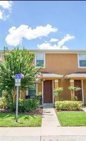 a front view of a house with a yard and potted plants