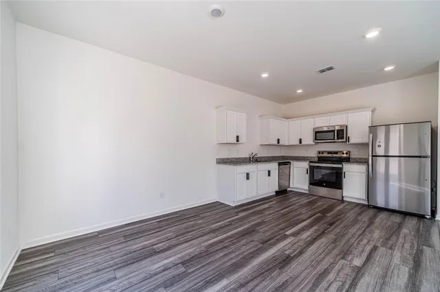 a large kitchen with a center island stainless steel appliances and cabinets
