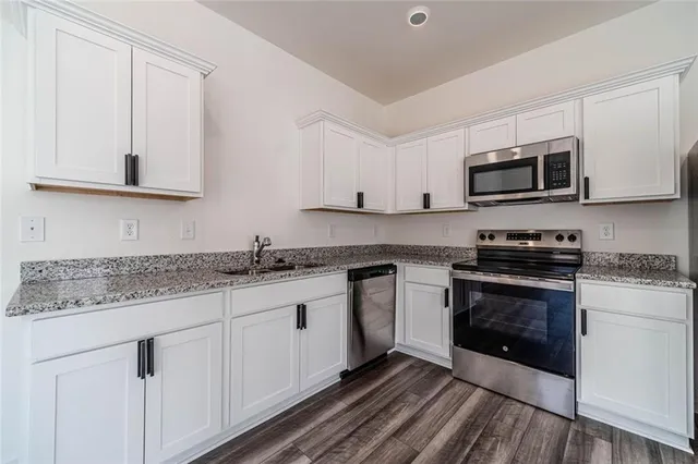 a kitchen with granite countertop a sink and a stove top oven