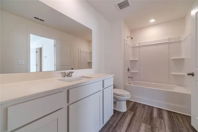 a bathroom with a sink a toilet and a large mirror