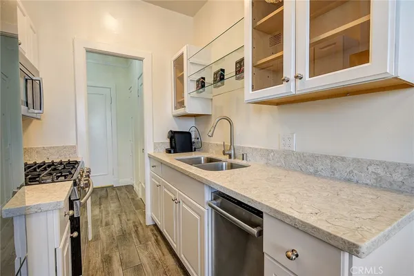 a kitchen with stainless steel appliances granite countertop a sink stove and cabinets