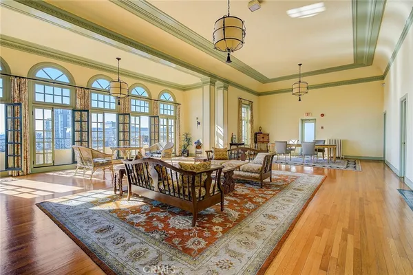 a living room with large couches a table and chairs with wooden floor