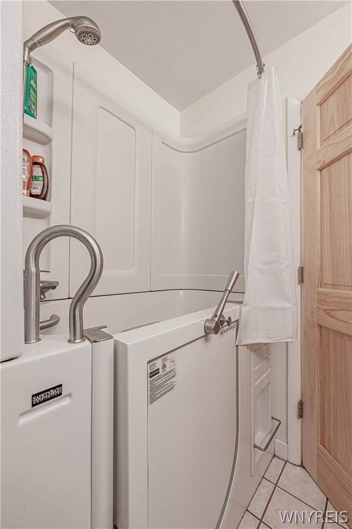 6775 Bear Ridge Road Pendleton, NY 14094 - Photo 25 of 48 An accessible walk-in tub highlights this tiled bathroom designed with modern ease of use.