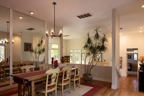 a kitchen with stainless steel appliances granite countertop a stove a sink a oven and a dining table with wooden floor