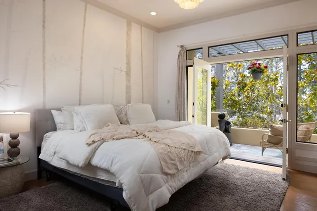 a bedroom with a large bed and a large window with outer view