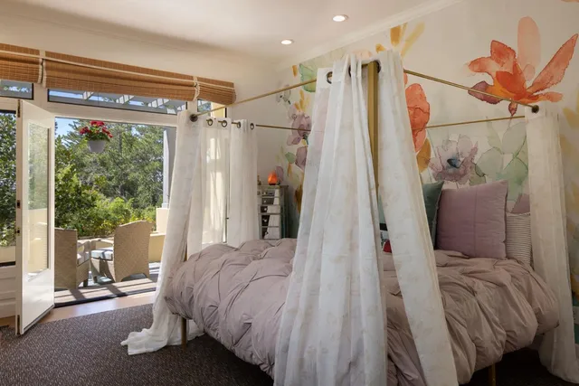 a work room with furniture a large window and a potted plant