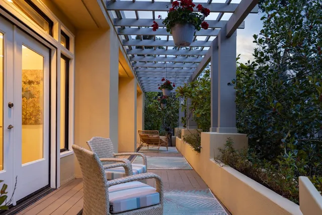 a view of a patio with chairs and table under an umbrella