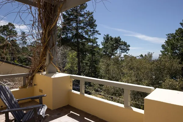 a view of a patio with chairs and table under an umbrella
