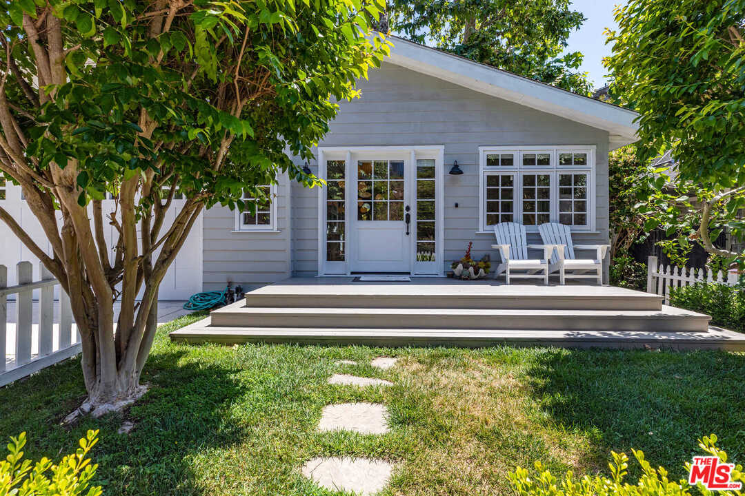 374 East Rustic Road Santa Monica, CA 90402 - Photo 3 of 21 a front view of a house with a yard table and chairs