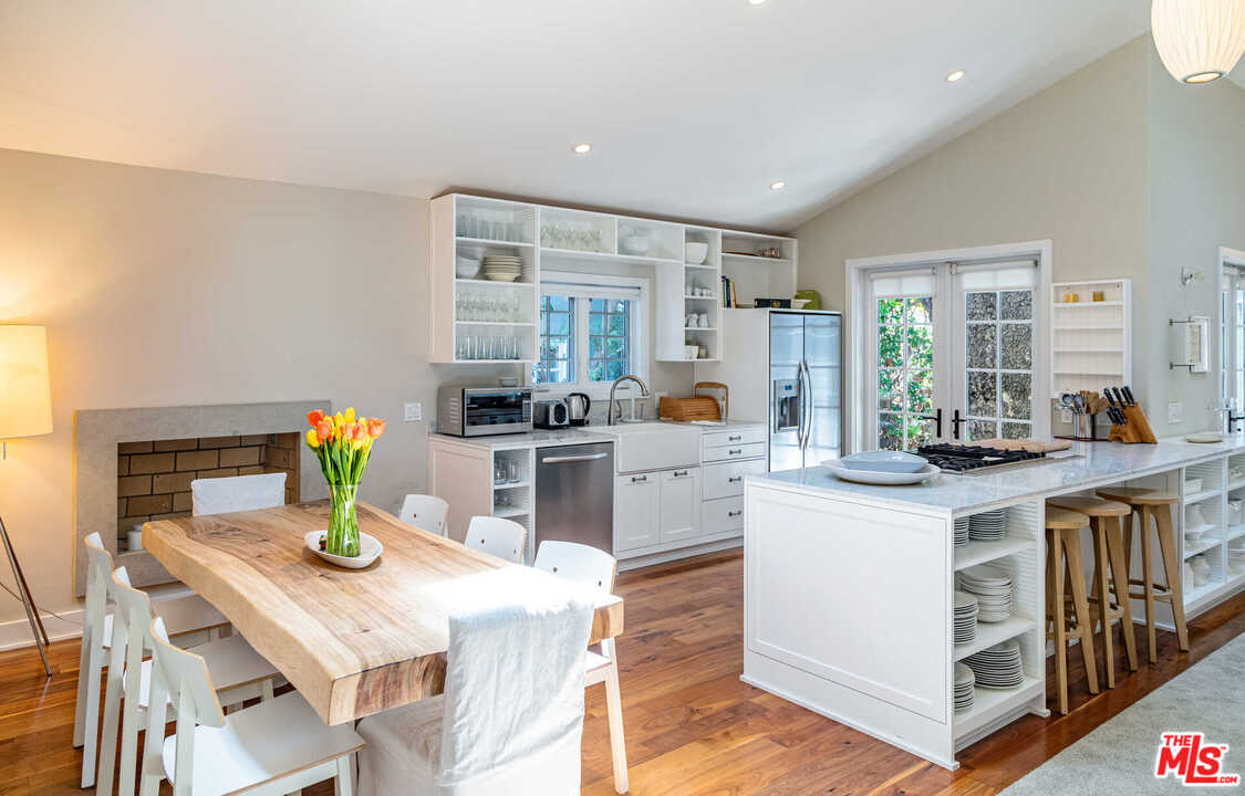 374 East Rustic Road Santa Monica, CA 90402 - Photo 8 of 21 a kitchen with stainless steel appliances granite countertop a stove a refrigerator a dining table and chairs