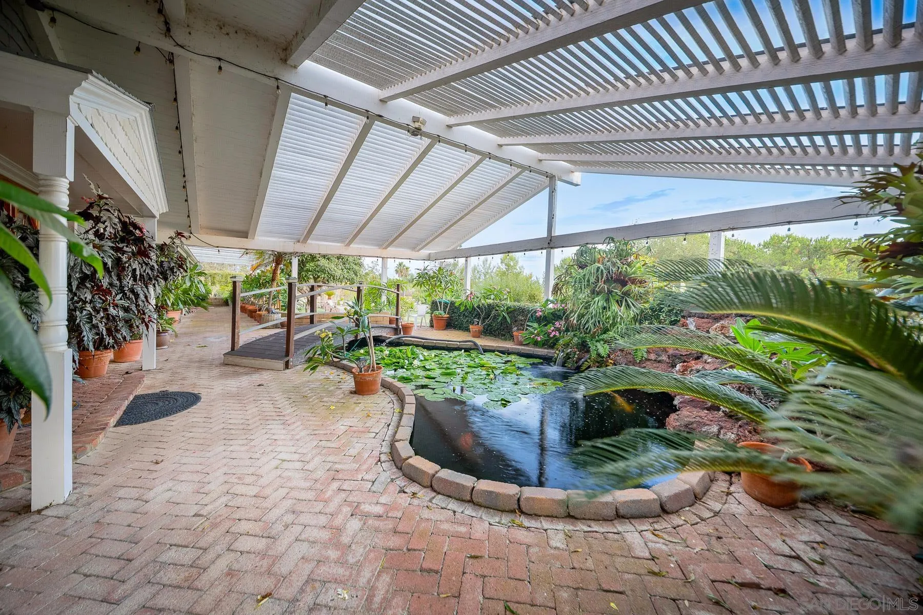 13764 McNally Road Valley Center, CA 92082 - Photo 3 of 26 a view of a patio with table and chairs potted plants