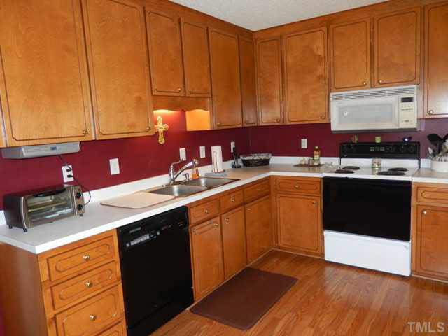3151 Sanders Road Willow Spring, NC 27592 - Photo 12 of 24 a kitchen with a sink stove and cabinets