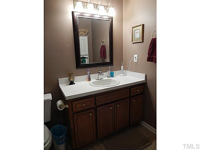 3151 Sanders Road Willow Spring, NC 27592 - Photo 15 of 24 a bathroom with a sink vanity and a mirror