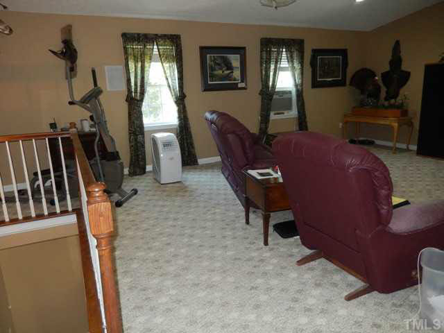 3151 Sanders Road Willow Spring, NC 27592 - Photo 20 of 24 a living room with furniture a window and gym equipment